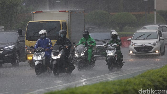 Sejumlah kendaraan melintas saat hujan di Bundaran HI, Jakarta, Jumat, (18/2/2022).