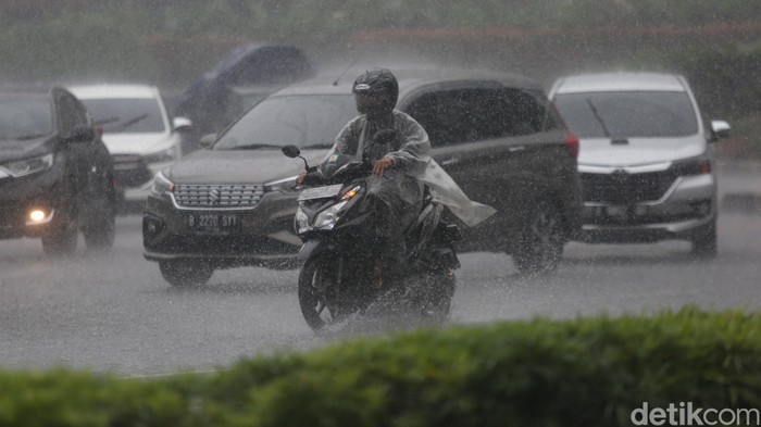 Sejumlah kendaraan melintas saat hujan di Bundaran HI, Jakarta, Jumat, (18/2/2022).