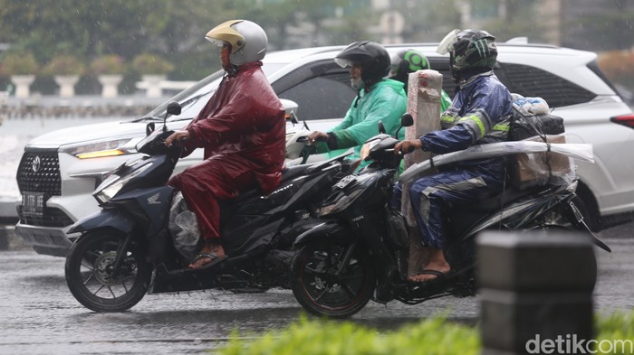Sejumlah kendaraan melintas saat hujan di Bundaran HI, Jakarta, Jumat, (18/2/2022).