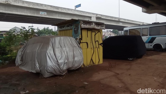 Sejumlah kendaraan milik warga yang parkir di kolong jalan tol Becakayu di Kalimalang kawasan Caman, Kota Bekasi, Jawa Barat, Jumat (18/2/2022).