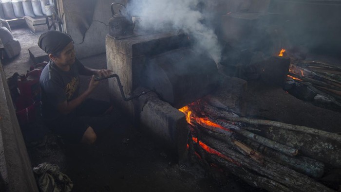 Pekerja memanggang biji kopi di tempat pengolahan biji kopi tradisional Nagari Koto Tuo, Kecamatan Sungai Tarab, Kabupaten Tanah Datar, Sumatera Barat, Jumat (18/2/2022). Nagari Koto Tuo dikenal sebagai daerah penghasil bubuk kopi di provinsi itu dan sedang dikembangkan menjadi kampung kopi karena 75 persen warganya bekerja sebagai pengolah biji kopi. ANTARA FOTO/Iggoy el Fitra/rwa.
