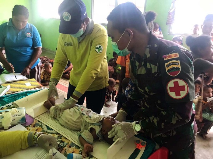 TNI Bantu Layanan Posyandu di Perbatasan Prajurit Satgas Pamtas RI-PNG Yonif 126/Kala Cakti Pos Waris bantu para Tenaga Kesehatan (Nakes) Puskesmas Model dalam kegiatan bakti kesehatan Pos Pelayanan Terpadu (Posyandu) dalam rangka meningkatkan dan memeratakan pelayanan kesehatan balita di Kampung Banda, Distrik Waris, Kabupaten Keerom.