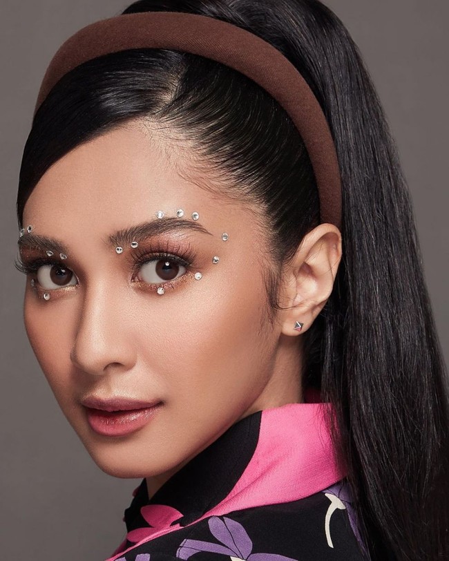 Untuk menyempurnakan penampilannya, Mikha mengenakan pulasan makeup natural. Bagian matanya diberikan aksen tambahan berupa berlian-berlian kecil yang ditempelkan di daerah luar sekeliling matanya. Foto: Instagram