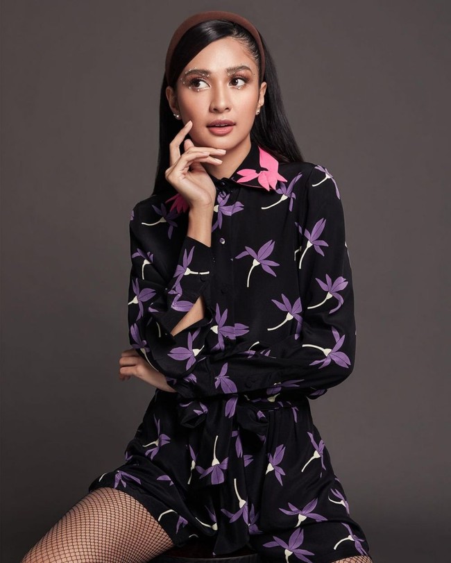 Melalui akun Instagram pribadinya, Mikha Tambayong terlihat membagikan hasil pemotretan terbarunya bersama Dickie Photographie. Mikha terlihat tampil cantik dengan mengenakan jumpsuit hitam bermotif bunga berwarna ungu. Bagian kerahnya terdapat aksen berwarna merah muda. Foto: Instagram