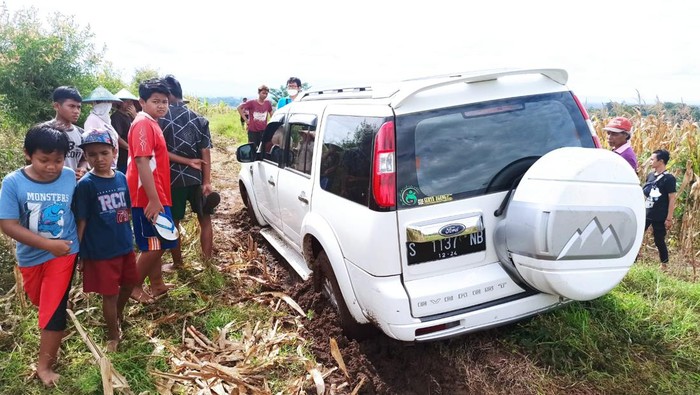 mobil terjebak di tengah sawah