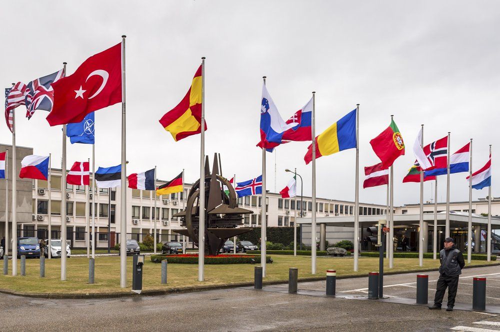 In this Tuesday July 28, 2015 file photo NATO country flags wave outside NATO headquarters in Brussels. It sounds strange to characterize the North Atlantic Treaty Organization as a huge gun club, but the comparison can be useful in understanding the world's biggest military alliance. Like many gun clubs, NATO _ where President Donald Trump is meeting other alliance leaders for the first time Thursday _ actually has no weapons of its own. (AP Photo/Geert Vanden Wijngaert, File)