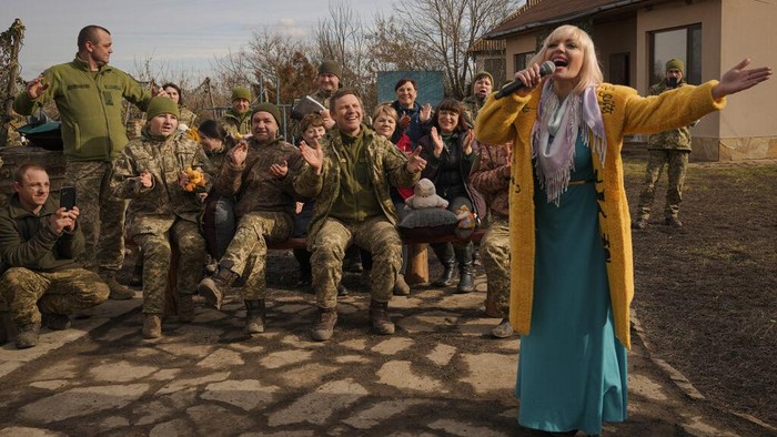 A Ukrainian servicewoman holds a teddybear during a performance by Larisa Borisenko, for Ukrainian troops with the 34th Battalion, near the frontline village of Krymske, Luhansk region, in eastern Ukraine, Saturday, Feb. 19, 2022. Ukrainian President Volodymyr Zelenskyy, facing a sharp spike in violence in and around territory held by Russia-backed rebels and increasingly dire warnings that Russia plans to invade, on Saturday called for Russian President Vladimir Putin to meet him and seek resolution to the crisis. (AP Photo/Vadim Ghirda)