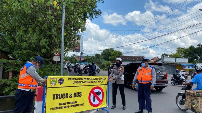 Petugas memasang papan penunjuk arah jaur alternatif selama perbaikan underpass Makamhaji, Sukoharjo.