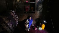 Seorang wanita duduk di tanah saat memasak di rumah satu kamarnya, di Kabul, Afghanistan, Minggu, 20 Februari 2022.