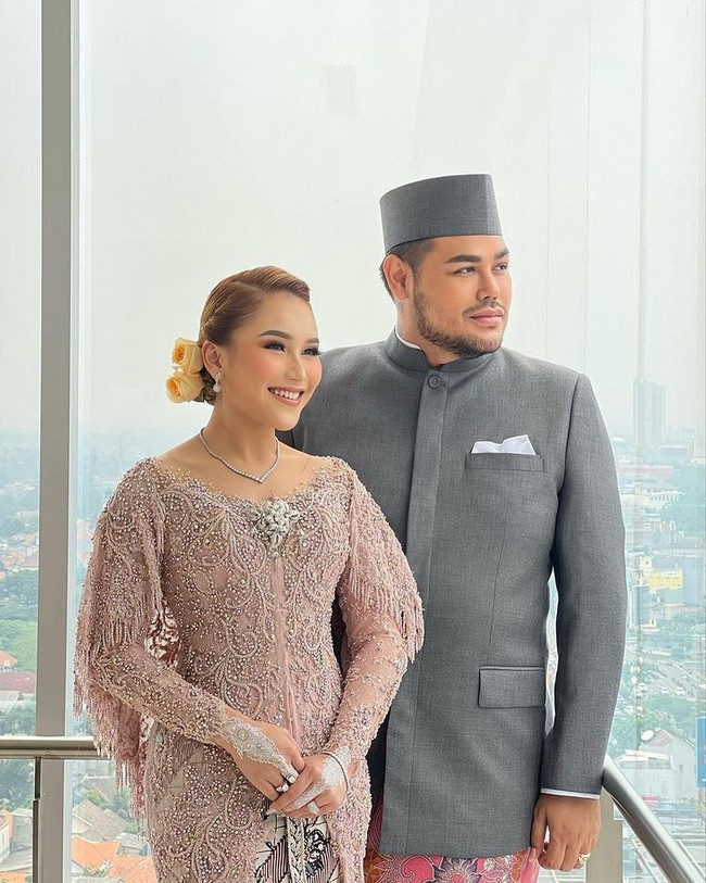 Sementara Ivan Gunawan mengenakan baju adat Betawi yang dilengkapi dengan beskap, Ayu Ting Ting tampil anggun dalam balutan kebaya berwarna nude. Pulasan makeup natural yang senada dengan busananya juga menambah pesona kecantikan Ayu Ting Ting. Foto: Instagram