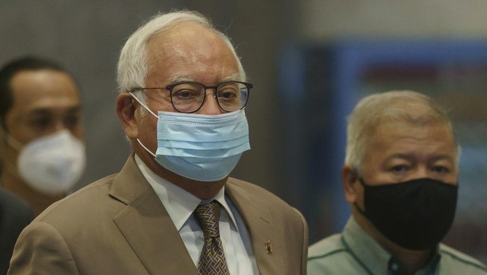 Former Malaysian Prime Minister Najib Razak, center, wearing a face mask arrives at Court of Appeal in Putrajaya, Malaysia, Monday, April 5, 2021. The court Monday began hearing an appeal by Najib to overturn his conviction and 12-year jail sentence linked to the massive looting of the 1MDB state investment fund that brought down his government in 2018. (AP Photo/Vincent Thian)