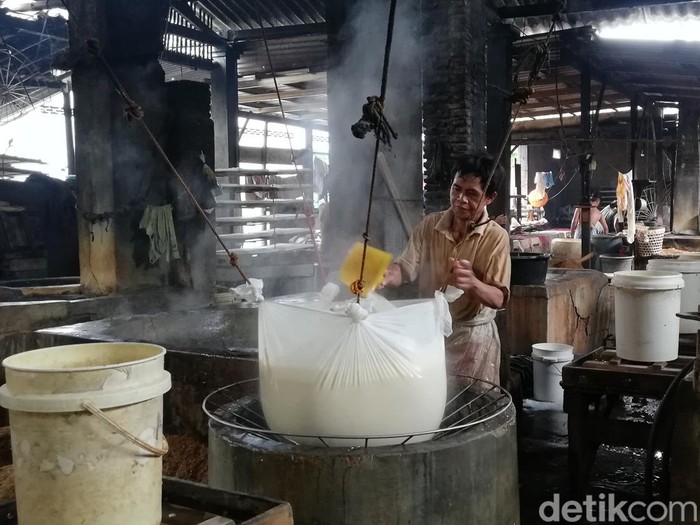 Pekerja memproduksi tahu.