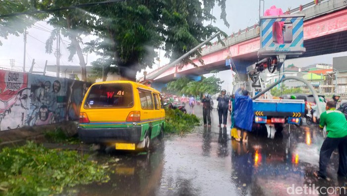 Pohon tumbang terjadi di kawasan Mayangkara, Wonokromo, Surabaya. Pohon dan lampu jalan tumbang menimpa angkot dan mobil