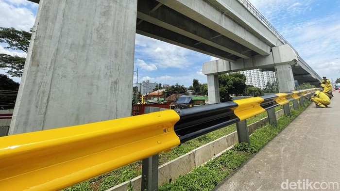 Agar terlihat kinclong, sejumlah pasukan kuning melakukan pengecatan pada pagar besi pembatas jalan, di jembatan Cawang, Jakarta Timur, Selasa (22/02/2022).