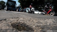 Pengguna jalan melintas di Jalan Ciputat Raya, Pondok Pinang, Kebayoran Lama, Jakarta Selatan, Selasa (22/2/2022). Pantauan pukul 10.00 WIB, jalanan tampak bergelombang.   
