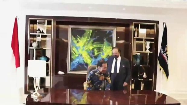 Momen saat Surya Paloh mempersilakan Presiden Jokowi duduk di kursi Ketua Umum NasDem, di NasDem Tower, Selasa (22/2/2022).