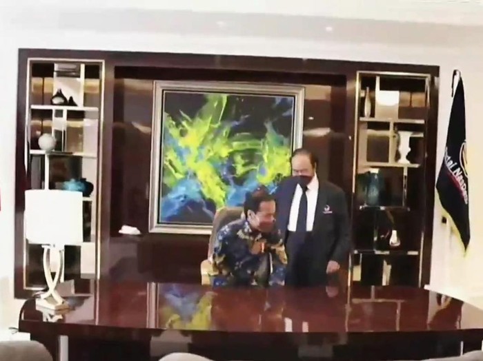 Momen saat Surya Paloh mempersilakan Presiden Jokowi duduk di kursi Ketua Umum NasDem, di NasDem Tower, Selasa (22/2/2022).