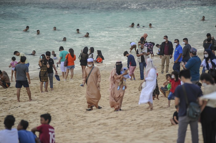 Terlihat suasana Pantai Melasti Ungasan di padati wisatawan lokal dan Internasional, Denpasar, Bali,
21 Februari 2022. Pemerintah telah membuka kunjungan wisatawan mancanegara (wisman) ke Indonesia melalui dua pintu masuk, yaitu Bali dan Kepulauan Riau, Dalam hal asuransi kesehatan, contohnya, berdasarkan kesepakatan kementerian dan lembaga terkait,
maka WNA (warga negara asing) diminta memiliki asuransi kesehatan, mempertimbangkan risiko yang ada. Foto: Ichalchem