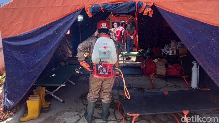 Penyemprotan disinfektan oleh petugas PMI di lokasi banjir.