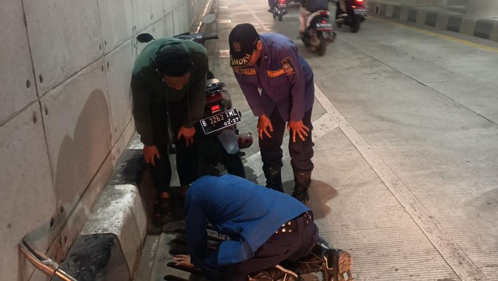 Petugas Damkar Bekasi membantu warga mengambil kunci di gorong-gorong (dok. Istimewa)
