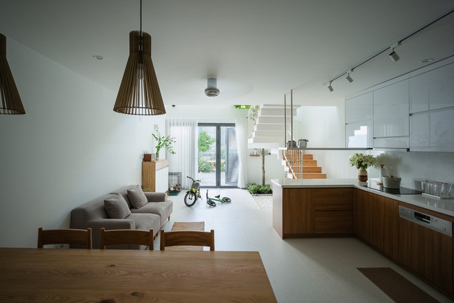 Rumah ini terbagi menjadi tiga lantai kemudian ada lantai mezzanine dan rooftop. Pada lantai pertama ada halaman, taman, dapur dan ruang makan. Halaman dibuat menyatu dengan dapur dan ruang makan agar pemilik rumah dapat mengawasi kegiatan dua anak mereka yang baru berusia lima dan tiga tahun. Foto: Dok. Quang Tran via Arch Daily