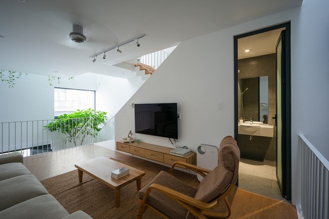 Setelah lantai satu atau lantai dasar, ada mezzanine yang fungsinya sebagai ruang tamu sekaligus ruang keluarga. Pada lantai ini ada juga gudang dan ruangan untuk mencuci serta setrika baju. Foto: Dok. Quang Tran via Arch Daily