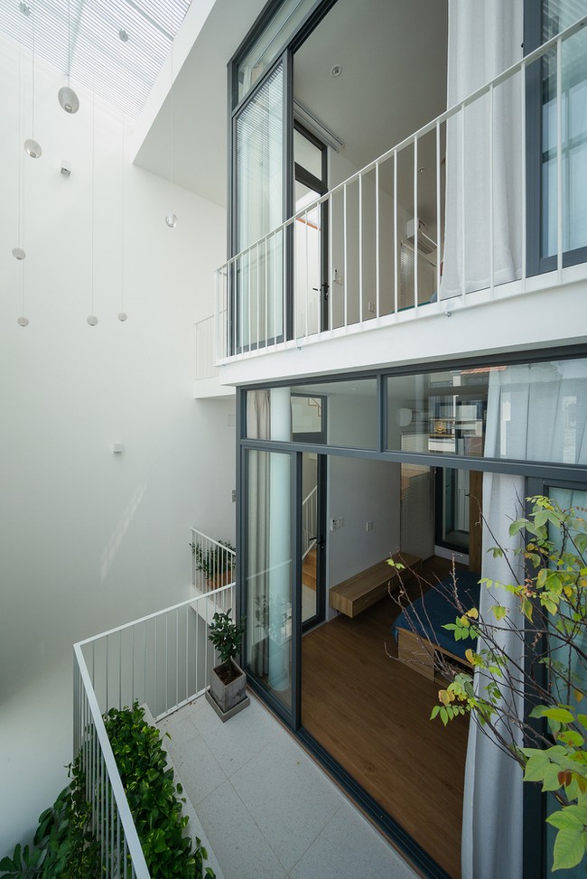 Rumah di gang ini didesain dengan jendela yang besar dan tinggi untuk memaksimalkan penerangan dari cahaya matahari. Agar privacy penghuni tetap terjaga, dihadirkan ventilasi pada jendela. Foto: Dok. Quang Tran via Arch Daily