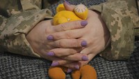 Seorang prajurit Ukraina dengan pewarna kuku memegang boneka di garis depan Krymske, wilayah Luhansk, di timur Ukraina, Sabtu, (19/2/2022). (AP Photo/Vadim Ghirda)