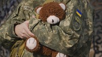 Seorang prajurit Ukraina memegang boneka beruang di garis depan Krymske, wilayah Luhansk, di timur Ukraina, Sabtu, (19/2/2022). (AP Photo/Vadim Ghirda)