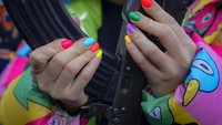 Warna-warni kuku yang diberi cat terlihat dari perempuan muda yang memegang senjata selama pelatihan tempur dasar untuk warga sipil, di Mariupol, wilayah Donetsk, Ukraina timur, Minggu, (13/2/2022). (AP Photo/Vadim Ghirda)