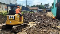 Alat berat juga dikerahkan untuk menangani puing-puing sisa banjir.