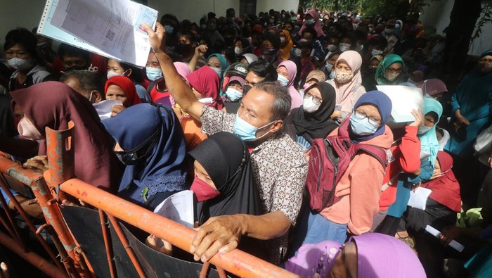 Warga Kediri Desak-desakan Ambil Bansos Sembako Warga menunggu panggilan saat penyaluran dana bantuan Program Sembako tahun 2022 di Kantor Pos Besar, Kota Kediri, Jawa Timur, Selasa (22/2/2022). Penyaluran dana bantuan program sembako senilai Rp600 ribu untuk 3 bulan kepada 11 ribu keluarga penerima manfaat di Kota Kediri tersebut diwarnai kerumunan dan saling dorong karena banyak warga datang tidak sesui dengan waktu yang telah ditentukan pada surat undangan. ANTARA FOTO/Prasetia Fauzani/foc.