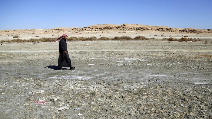 Danau Terbesar Kedua di Irak Mengering, Banyak Ikan Mati Fishermen stand on the bank of Razzaza Lake, also known as Lake Milh, Arabic for salt, in the Karbala governorate of Iraq, Feb. 14, 2022. The lake was once a tourist attraction known for its beautiful scenery and an abundance of fish that locals depended on. Dead fish now litter its shores and the once-fertile lands around it have turned into a barren desert. (AP Photo/Hadi Mizban)