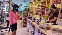 Bagian barista tempat memesan kopi. Terlihat lampu ultraviolet di beberapa rak untuk perawatan tanaman dalam ruang.