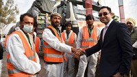 Dubes Afghanistan untuk India, Farid Mamundzay (kanan) berjabat tangan dengan salah satu sopir truk yang mengangkut gandum, di Amritsar, India, Selasa (22/2/2022).