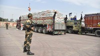 Tentara perbatasan India berjaga di depan truk berisi bantuan gandum yang akan dikirim ke Afghanistan. Negara miskin dibawah rezim Taliban itu mengandalkan bantuan asing untuk bertahan hidup.