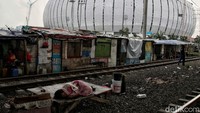 Seorang warga tertidur di kawasan bantaran rel kereta api Kampung Bayam, Papanggo, Tanjung Priok, yang berada di sekitar area pembangunan Jakarta International Stadium (JIS), Jakarta Utara, Selasa (22/2/2022).
