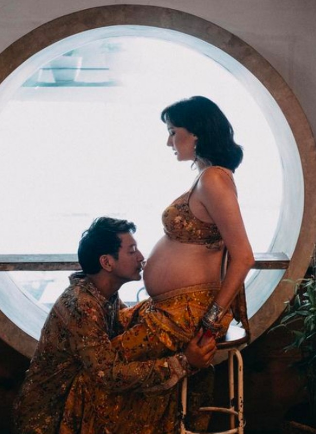 Dalam potret kehamilan lainnya, Nadine dan Dimas tampil dengan busana batik. Dalam foto ini, Dimas mencium baby bump sang istri. Foto: dok. Instagram/@nadinelist