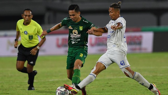 Pesepak bola Persebaya Reva Adi Utama (tengah) berebut bola dengan pemain Arema FC Dendi Santoso dalam pertandingan sepak bola Liga 1 di Stadion I Wayan Dipta, Gianyar, Bali, Rabu (23/2/2022). ANTARA FOTO/Nyoman Budhiana/rwa.