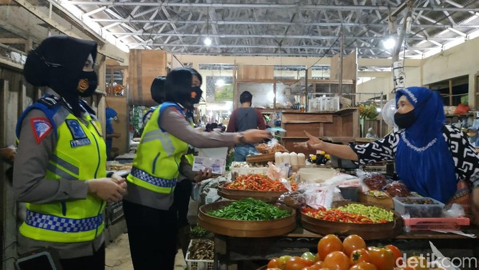 Polwan Pacitan bagi masker ke pedagang