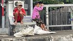 Mencari Rezeki Sambil Gendong Anak di Jalanan Jakarta