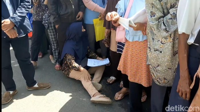 Seorang lansia duduk di aspal seraya mengantre pencairan bantuan langsung tunai di Cikalang, Kota Tasikmalaya