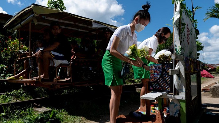 Children select books from the makeshift trolley which serves as a mobile library, near the railroad, in Tagkawayan, Quezon Province, Philippines, February 15, 2022. Picture taken February 15, 2022. REUTERS/Lisa Marie David