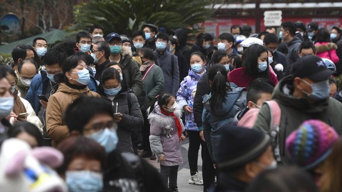 A man holding his bicycle with a school bag on it gets a throat swab during a mass COVID-19 test at a residential compound in Wuhan in central Chinas Hubei province, Tuesday, Feb. 22, 2022. Wuhan, the first major outbreak of the coronavirus pandemic has reported more than dozen new coronavirus cases this week, prompting the authority to step up precautious measures. (Chinatopix via AP)