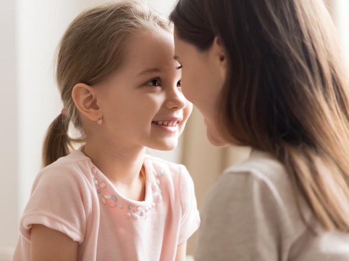 1163242601 Close up of cute little daughter cuddle with young mom look in eyes enjoy sweet time together, smiling preschooler girl have tender moment with mother or nanny showing love and affection