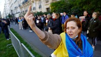 (Gambar sensitif) Seorang wanita di Paris berpose di depan kamera sebagai bentuk protes anti-perang di depan Kedutaan Besar Ukraina. REUTERS/Gonzalo Fuentes.