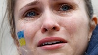 Seorang demostran pro-Ukraina di London, Inggris, terlihat meneteskan air mata saat menggelar aksi di Downing Street. REUTERS/Peter Cziborra.