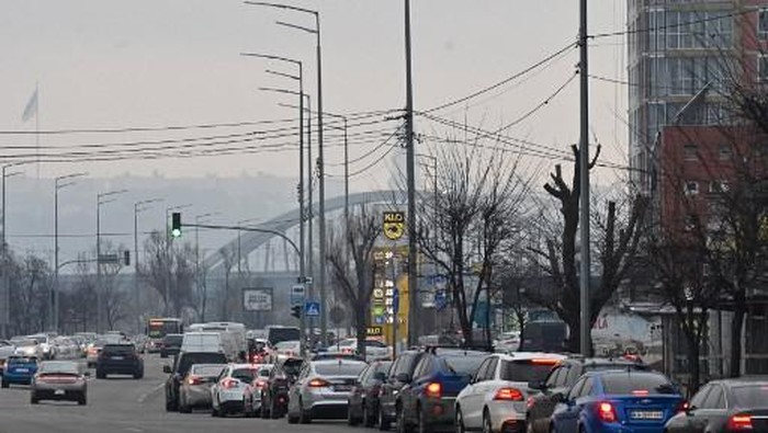 People queue to a petrol station in Kyiv on February 24, 2022. - Russian President Vladimir Putin announced a military operation in Ukraine on Thursday with explosions heard soon after across the country and its foreign minister warning a 