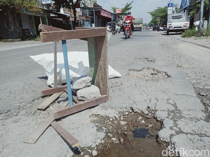 Dingklik atau bangku kayu dipasang di tengah jalan rusak penghubung Delanggu-Juwiring, Desa Bulan, Kecamatan Wonosari.