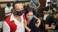 Jerinx datang ke ruang sidang bersama Nora yang memakai baju serba hitam.